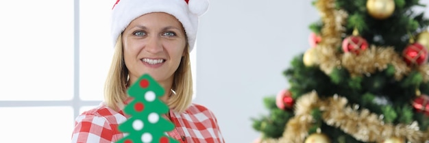 Baumeisterin im Weihnachtsmann-Hut auf dem Hintergrund des Berufes des Weihnachtsbaumbauers und