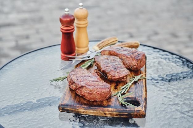 Baumsaftige gegrillte Streifensteaks auf einem Holzschneidebrett