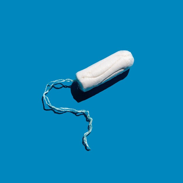 Baumwolltampon auf blauem, festem Hintergrund Pflege der weiblichen Hygiene