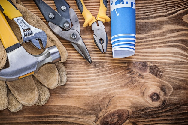 Bauplan Schutzhandschuhe Klauenhammer Greifzange Stahlschneider Rollgabelschlüssel auf Holzbrett