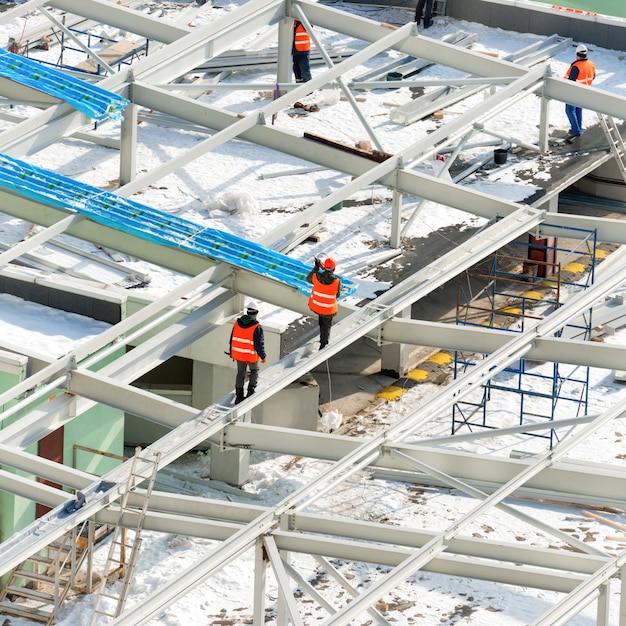 Baustelle mit Arbeitern auf dem Gebäudedach