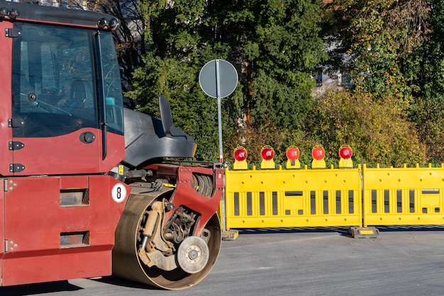 Baustraßenwalze auf der Fahrbahn Gelbe Sicherheitsbarrieren mit rotem Signal