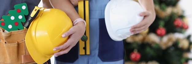 Bauteam mit Werkzeugen auf dem Hintergrund des Baumbaus des neuen Jahres und des Weihnachtskonzepts