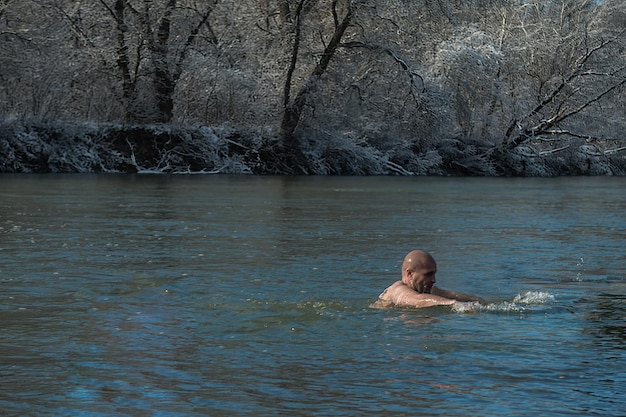 Bautismo e inmersión en el agua del río al aire libre en invierno