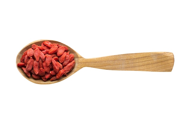 Baya de goji en cuchara de madera aislada sobre especia de fondo blanco para cocinar comida vista superior