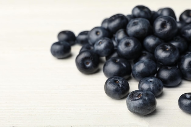 Bayas de acai frescas en la vista de cerca de la mesa de madera blanca Espacio para texto