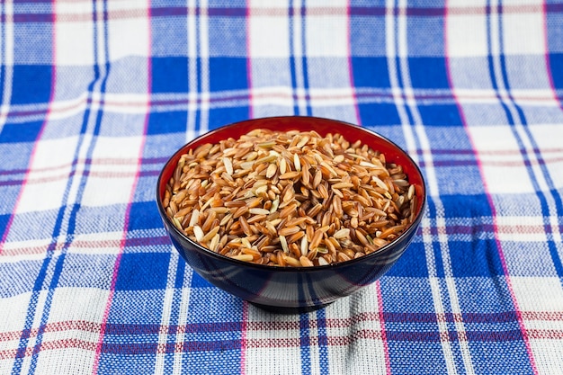 Bayas de arroz integral tailandés en la tela tailandesa de fondo