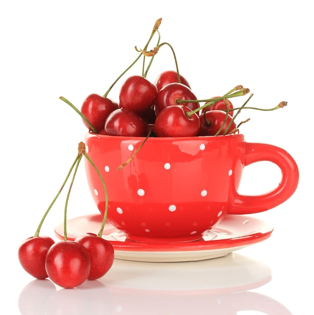 Bayas de cereza en taza aislado en blanco