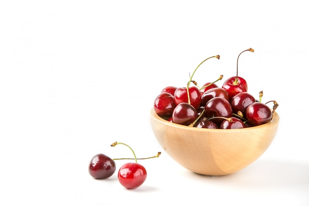 Bayas de cereza en un tazón de madera