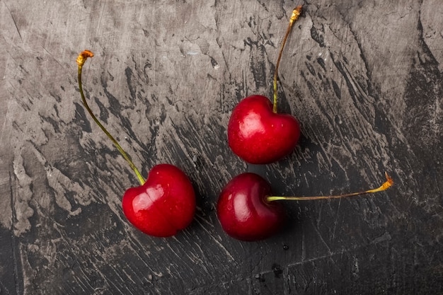 Bayas de cerezas frescas sobre una mesa oscura