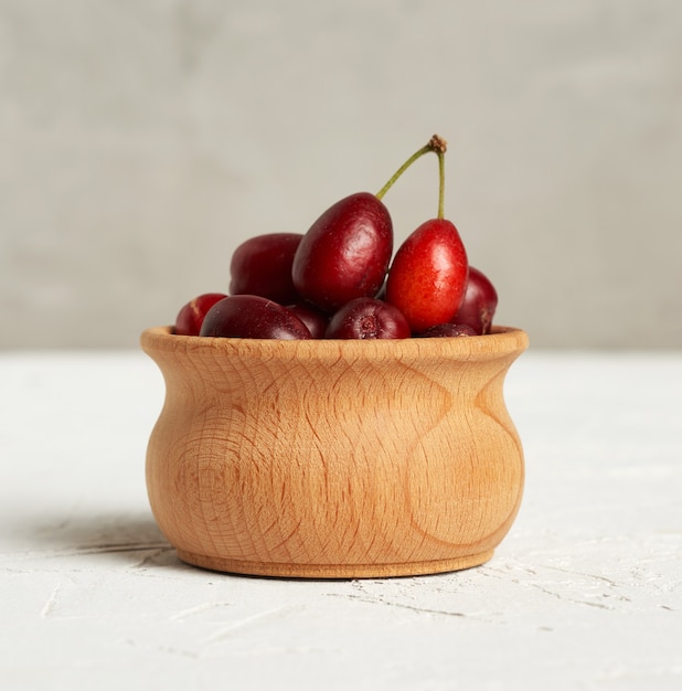 Bayas de cornejo rojo maduras en un cuenco de madera