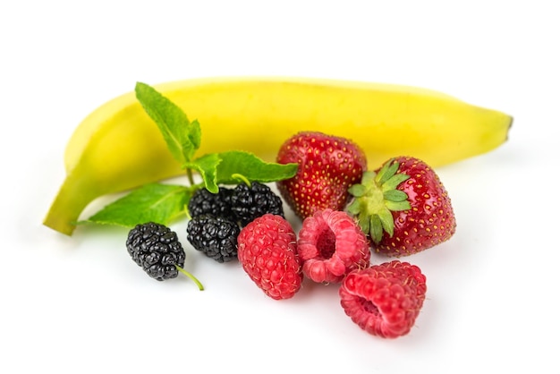 Bayas en un fondo blanco fresas morera plátano frambuesa hojas de menta primer plano