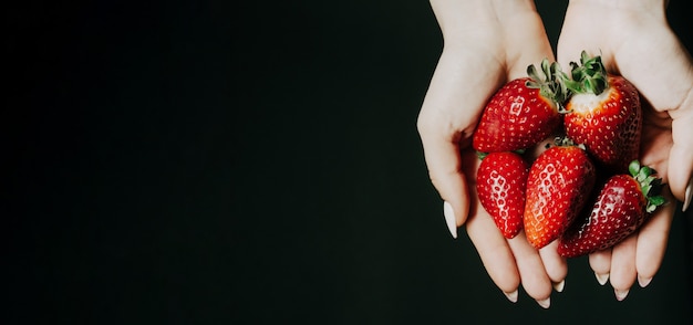 Bayas de fresa en manos de mujeres.