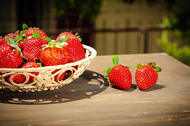 Bayas de fresas jugosas en un cuenco de mimbre en estilo rústico