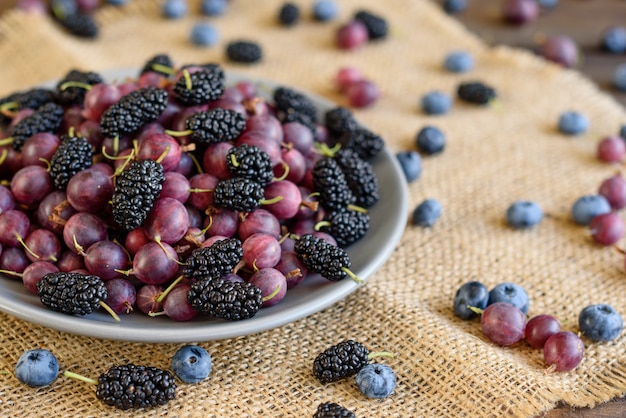 Bayas frescas de arándanos, moras y grosellas en un plato