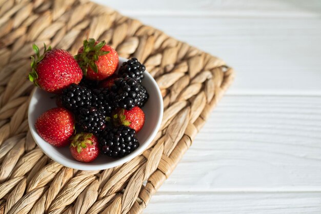 Bayas de moras y fresas maduras en un plato