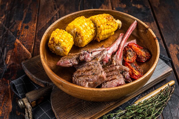 BBQ Chuletas asadas filetes de cordero, cordero en un plato de madera. Fondo de madera oscura. Vista superior.