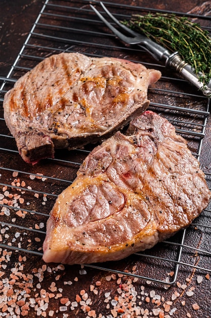 BBQ gegrillte Schweinelendensteaks vom Nackenfiletfleisch auf dem Grill dunkler Hintergrund Ansicht von oben