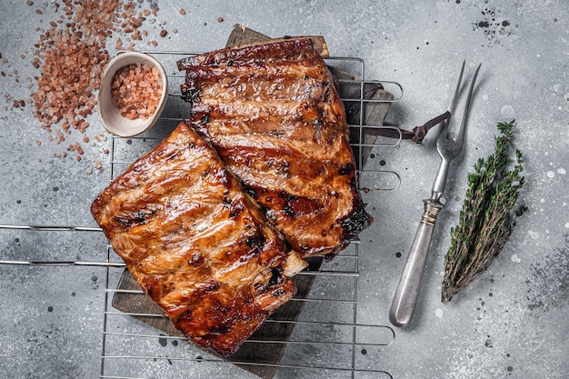 BBQ gegrillte Schweinerippchen in Barbecue-Sauce auf einem Grill Grauer Hintergrund Ansicht von oben