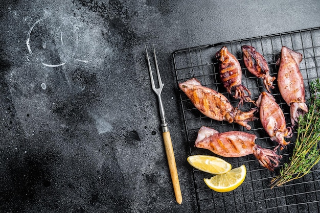 Bbq Tintenfisch Calamary auf einem Gestell Schwarzer Hintergrund Ansicht von oben Kopieren Sie Platz