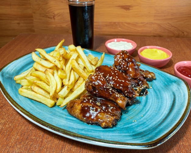 BBQ Wings mit Pommes Frites, Mayonnaise, Ketchup und Senf.