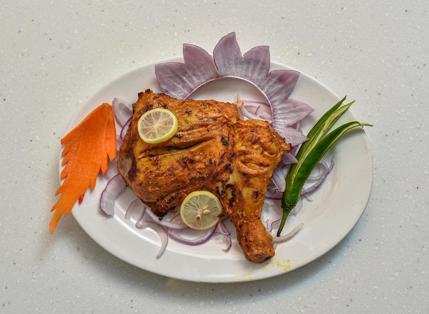 Bbq würziges Hähnchenbruststück mit Zitronenscheibe serviert in einem Gericht isoliert auf grauem Hintergrund Draufsicht auf indisches pakistanisches Essen