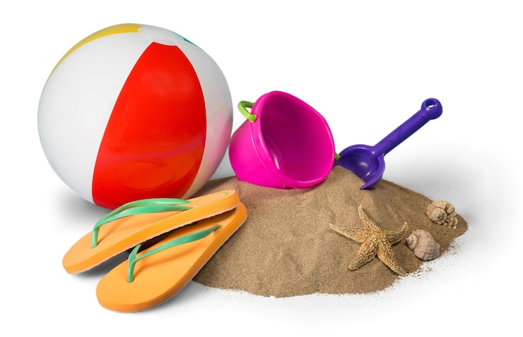 Foto beach ball, spielzeug und flip-flops auf sand isoliert auf weiß