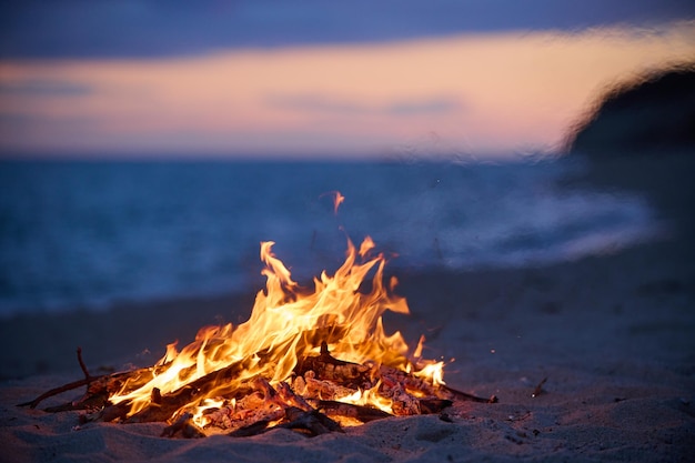 Foto beach bonfire selektiver fokus mit schönem sonnenuntergang oder sonnenaufgang niemand