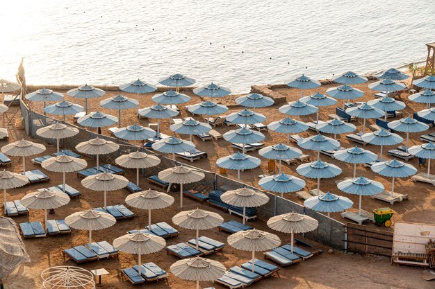 Beach Club am Morgen ohne Menschen und blau-weiße Sonnenschirme