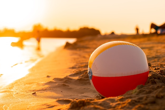 Beachball an der Küste bei warmem Sonnenuntergang