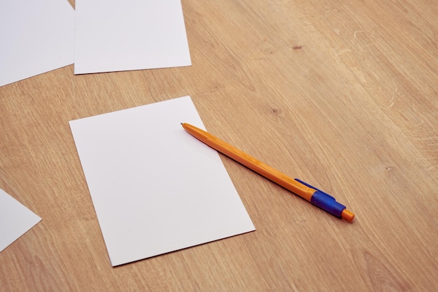 Beachten Sie Papiere oder Karten und einen gelben Stift auf einem Holztisch.