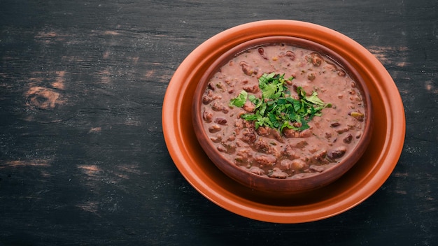 Bean Haricot Suppe georgische traditionelle Küche auf dem alten hölzernen Hintergrund freier Platz für Text Ansicht von oben