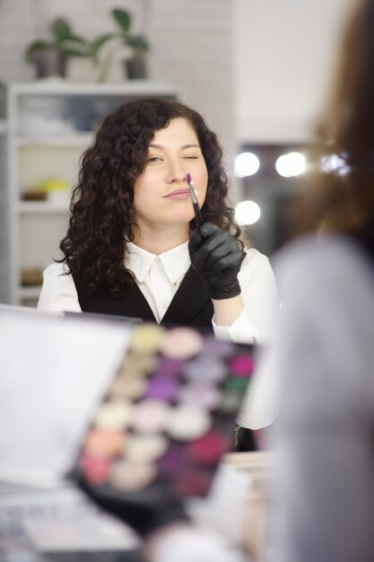 Beautician joven que se divierte durante trabajo en un salón de belleza.