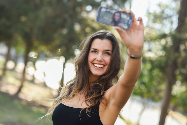 Beautiful young woman selfie no parque