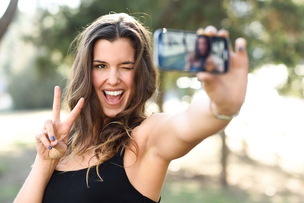 Beautiful young woman selfie no parque