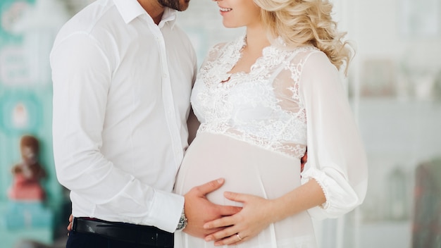 Beautiiful casal de mulher grávida e o marido abraçando.