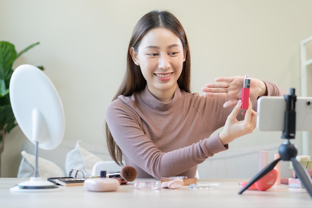 Beauty Blogger asiatische junge Frau Mädchen Vlogger Make-up Gesicht zeigt Bewertungen Kosmetikprodukte während der Aufnahme von Video-Tutorials, um sie in sozialen Medien zu teilen Business Online Influencer auf dem Smartphone