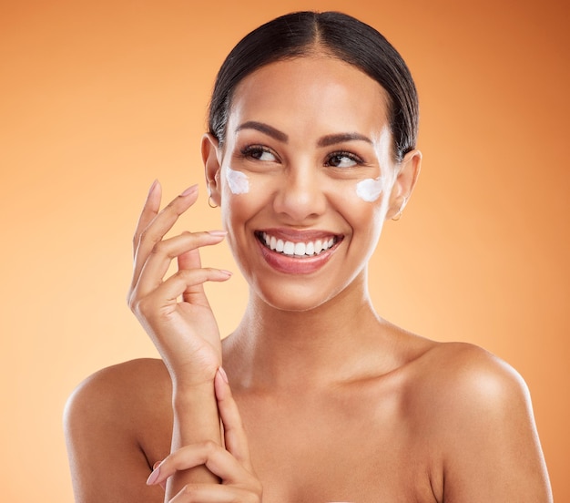 Beauty Hautpflege und Gesichtscreme auf Frau mit Lächeln zufrieden mit Produkt für die Haut vor braunem Studiohintergrund Fröhliches Latino-Modell mit Make-up-Kosmetik für Wellness-Kosmetik oder Dermatologie
