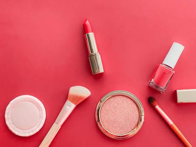 Beauty-Make-up und Kosmetik-Flatlay-Design mit Copyspace-Kosmetikprodukten und Make-up-Tools auf korallenrotem Hintergrund, girly und femininem Stilkonzept