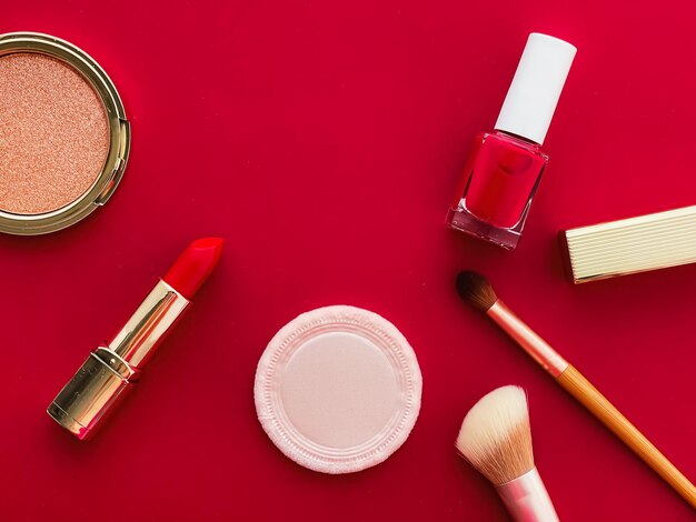 Beauty-Make-up und Kosmetik-Flatlay-Design mit Copyspace-Kosmetikprodukten und Make-up-Tools auf rotem Hintergrund, girly und feminines Stilkonzept