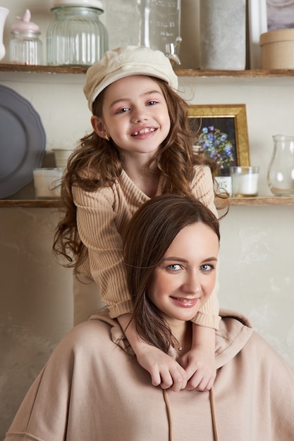 Beauty-Mode-Mutter und Tochter. Familienfotoshooting, Freude und lustige Emotionen. Umarmung einer Frau und eines Mädchens