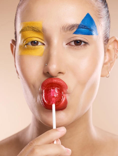 Beauty Paint Face Art und Frau mit kreativem Make-up-Design, Hautpflege oder Luxus-Gesichtskosmetik Farbkreativitätslutscher und Porträt eines ästhetischen Modellmädchens mit roten, blauen und gelben Formen