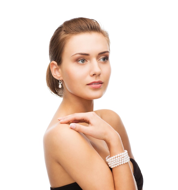 Beauty- und Schmuckkonzept - schöne Frau mit Perlenohrringen und Armband