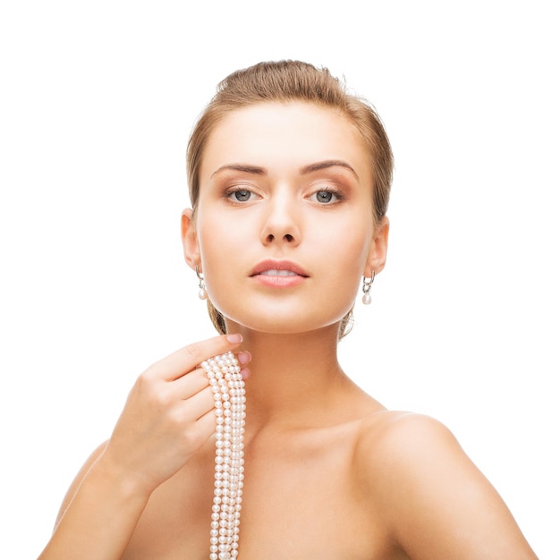 Beauty- und Schmuckkonzept - schöne Frau mit Perlenohrringen und Halskette