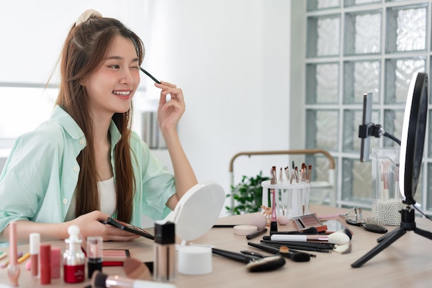 Beauty Vlogger-Konzept Junge Frau trägt Lidschatten auf die Augenlider auf, um das Produkt auf Vlog zu überprüfen