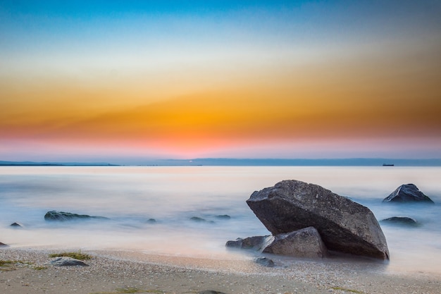 Beautyful calm sunrise na praia rochosa