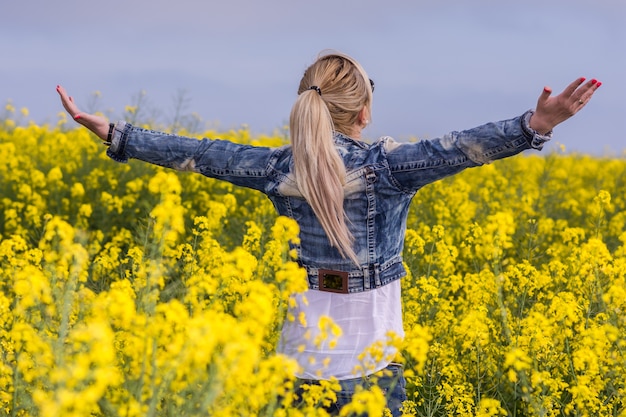 Foto beautyful mulher em floração campo amarelo com estupro