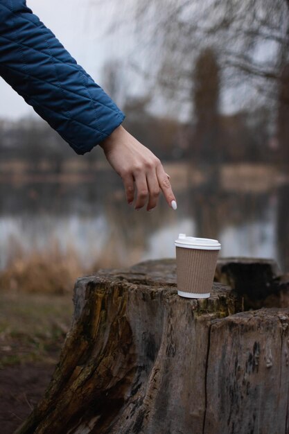 Beba café na natureza em um copo de papel ecológico