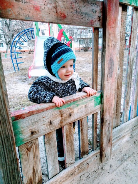 bebé de 1 año jugando con arena en el patio de recreo