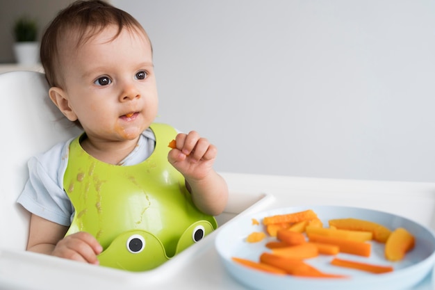 Foto bebê adorável brincando com comida